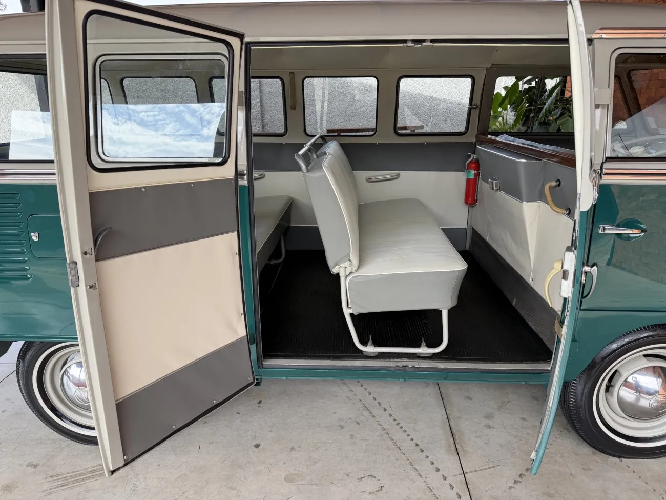 Interior lateral da VW Kombi Luxo 1965 com bancos e portas abertas