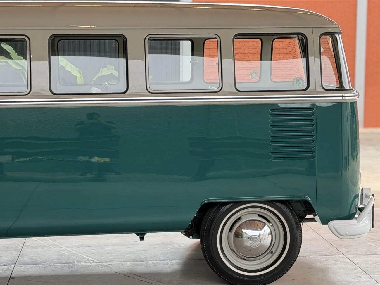 Parte lateral traseira da VW Kombi Luxo 1965 com roda e entradas de ventilação