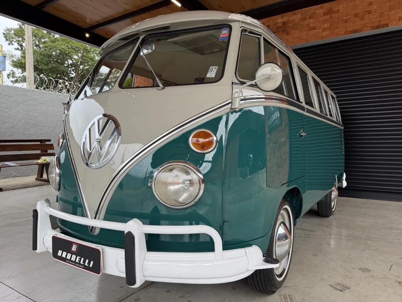 VW Kombi Luxo 1965 em ângulo dianteiro baixo com emblema Volkswagen e para-choques