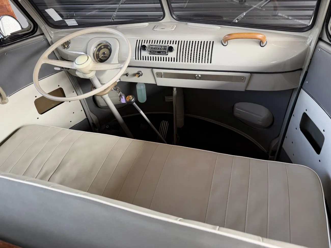Cabine dianteira da VW Kombi Luxo 1965 mostrando banco painel e volante