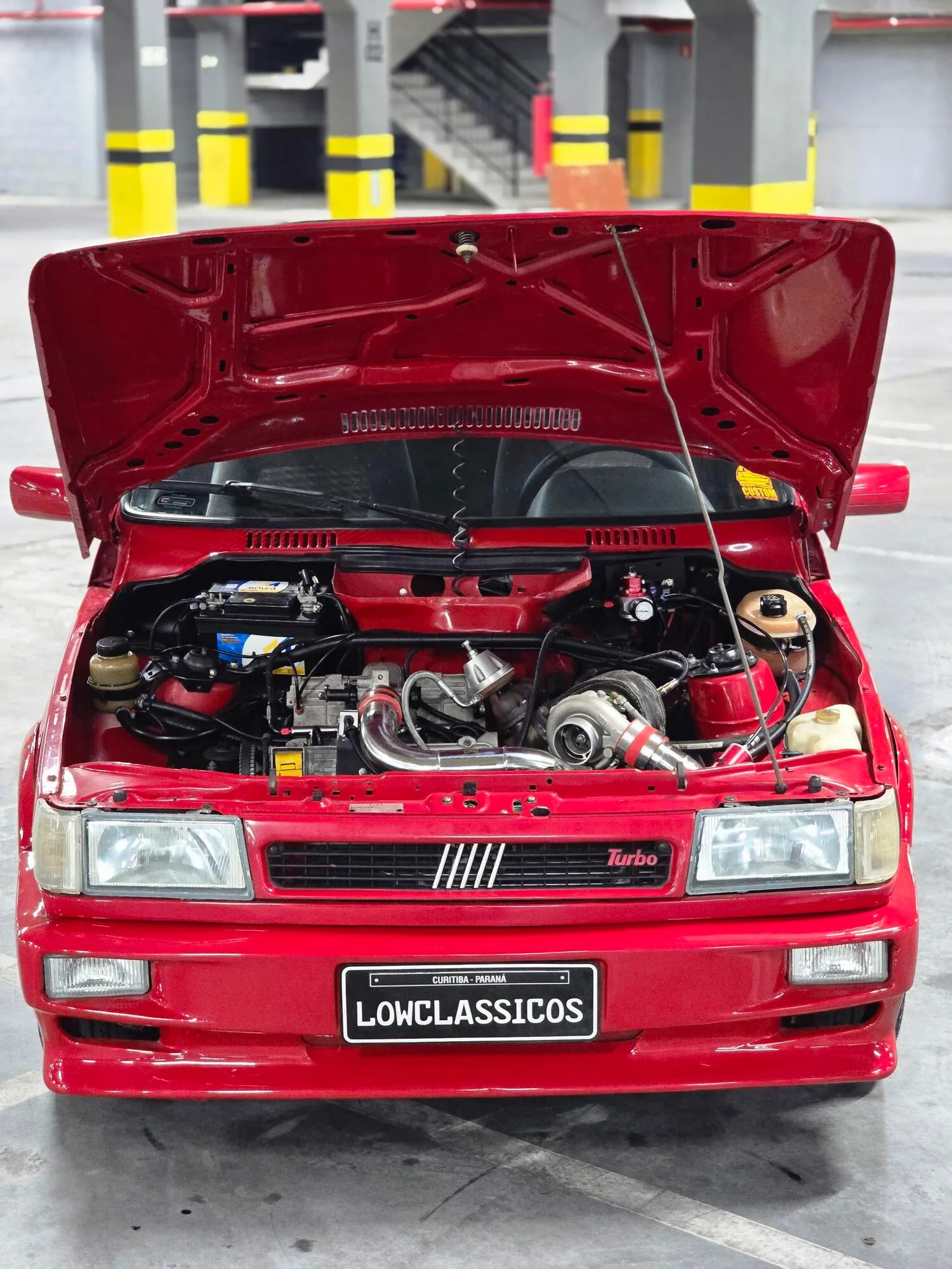 Fiat Uno Turbo 1994 de frente com capô aberto e motor visível
