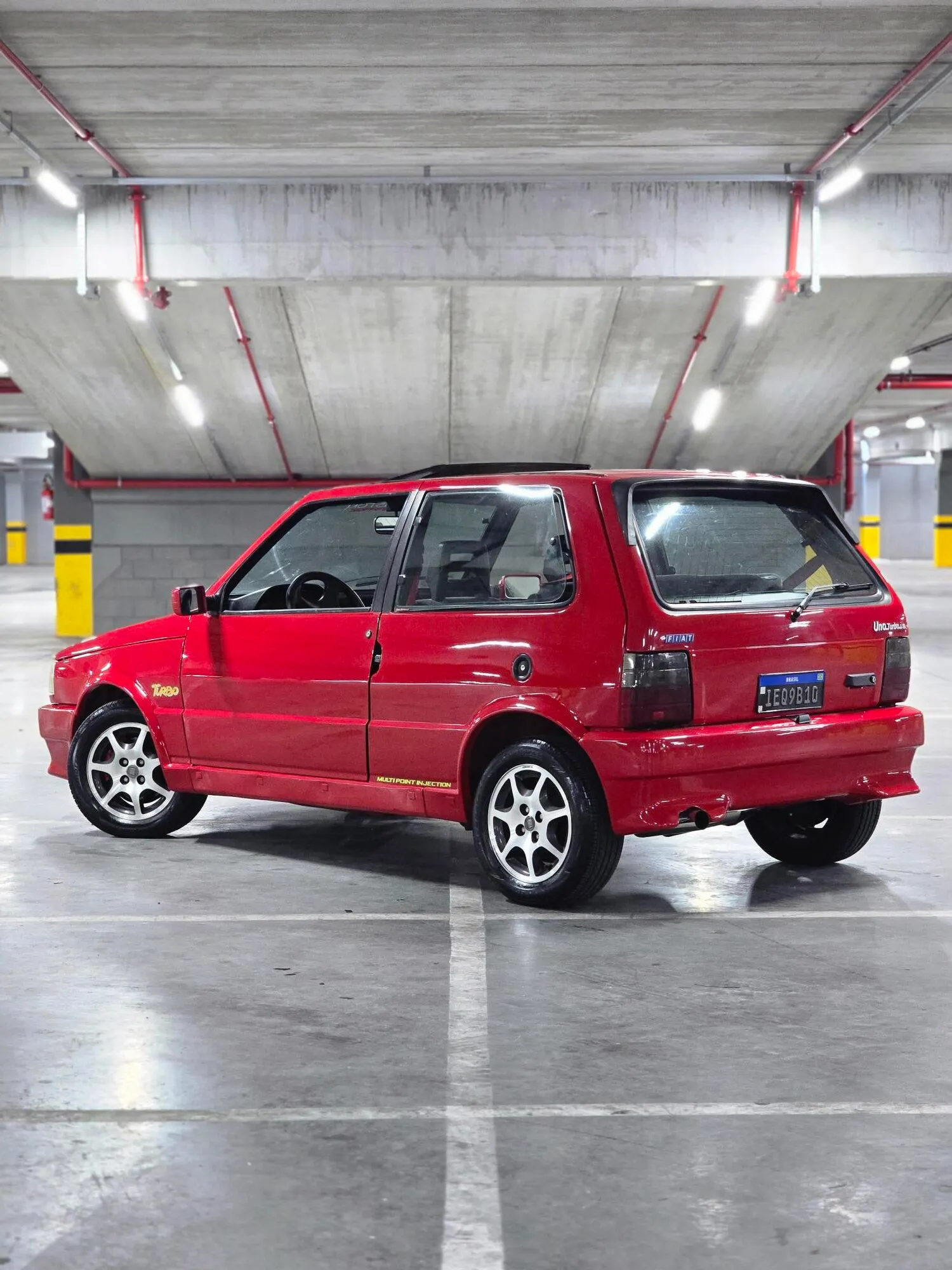 Fiat Uno Turbo i.e. 1994 vermelho visto pela traseira em três quartos