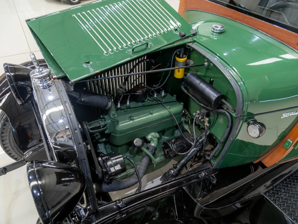 Cofre do motor aberto do Ford Model A Furgão 1929, mostrando motor de quatro cilindros, radiador e componentes elétricos