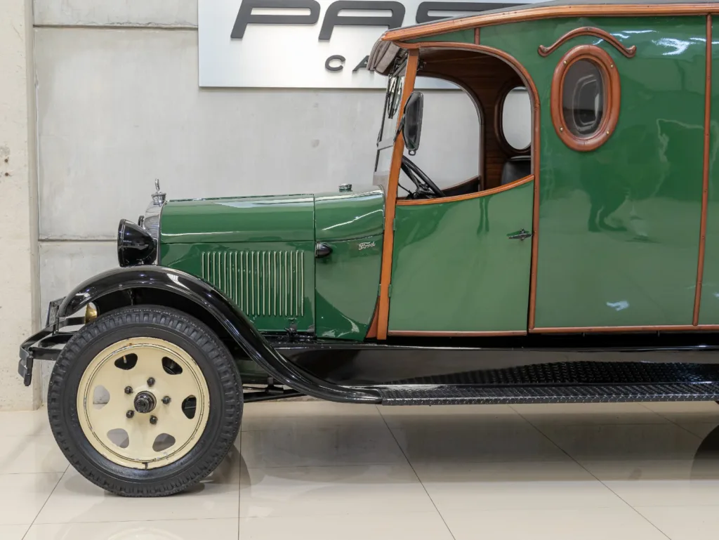 Detalhe lateral dianteiro do Ford Model A Furgão 1929 com pintura verde, madeira envernizada e janela oval
