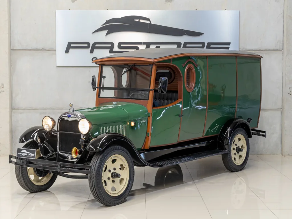 Ford Model A Furgão 1929 restaurado em vista dianteira lateral, com faróis acesos e acabamento verde e madeira
