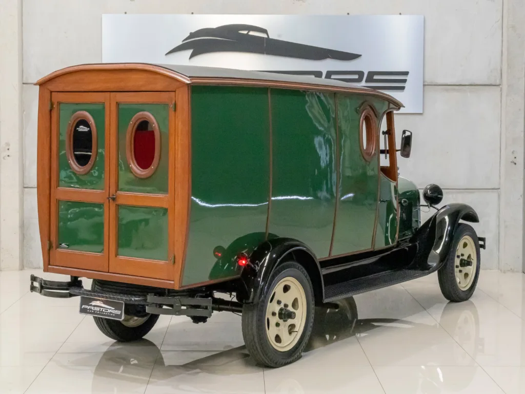 Ford Model A Furgão 1929 visto por trás na diagonal, com portas traseiras de madeira e janelas ovais