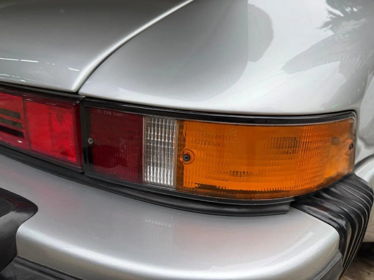 Detalhe da lanterna traseira, para-choque e pintura prata do Porsche 930 Turbo 1975
