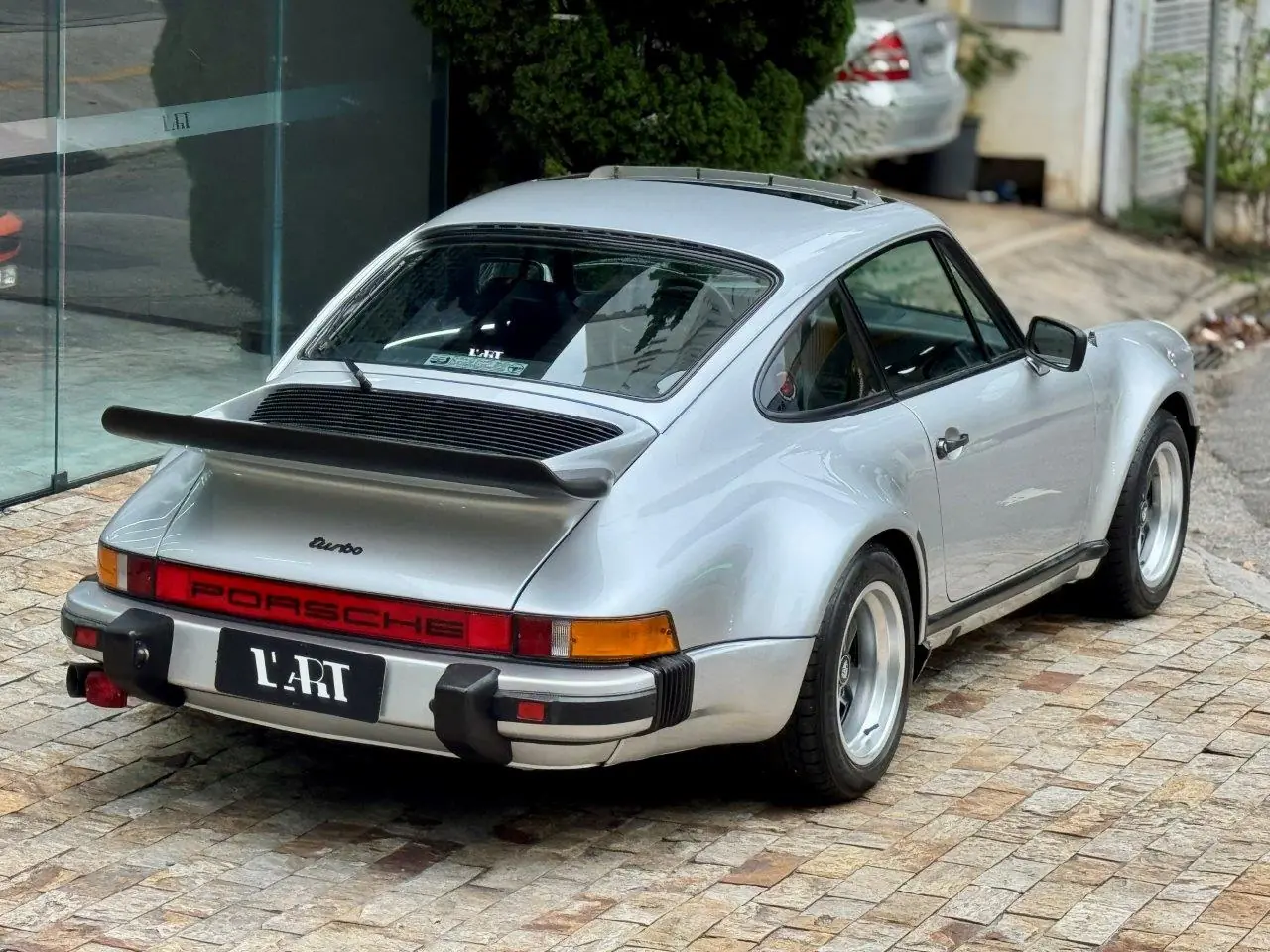 Porsche 930 Turbo 1975 em vista traseira de três quartos destacando a asa tipo whale tail